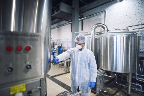 technologist-controlling-machine-production-plant-min