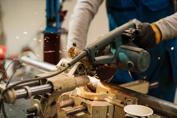 worker-working-with-circular-grinder-metal-with-sparks-min